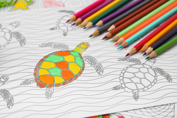 Disegno da colorare e matite sul tavolo, primo piano - Foto, immagini