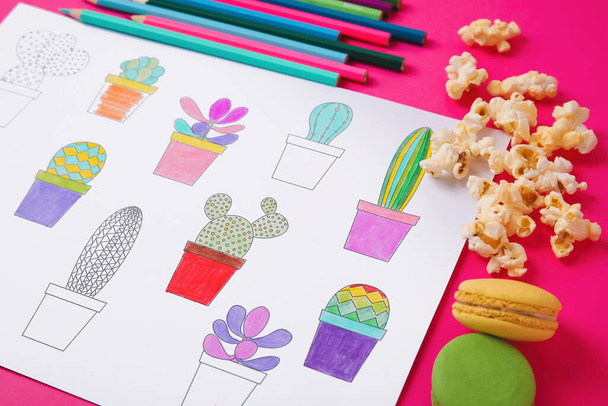 Coloring picture, macaroons and pencils on table, closeup - Photo, Image
