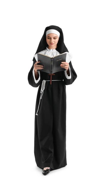 Молодая монахиня с Библией на белом фоне - Фото, изображение