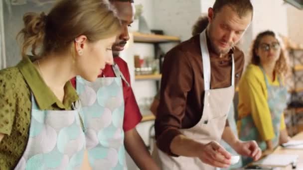 Чоловічий шеф-кухар дає інгредієнт молодим багатоетнічним студентам за запах, пояснюючи рецепт під час кулінарного майстер-класу
 - Кадри, відео