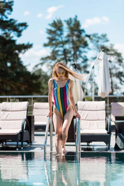 Donna in costume da bagno a piedi per piscina all'aperto  - Foto, immagini