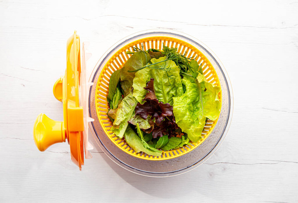 Vue du dessus du saladier avec des feuilles vertes à l'intérieur. Manière confortable pour laver et sécher les feuilles de salade. - Photo, image