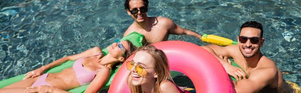 happy interracial friends laughing while resting in swimming pool, banner - Photo, Image