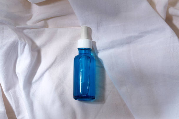 bottle of serum on white sheet - Photo, image