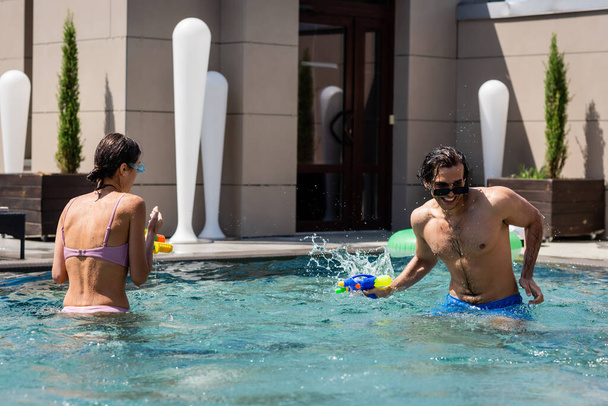 молодые друзья проводят время в бассейне на курорте - Фото, изображение