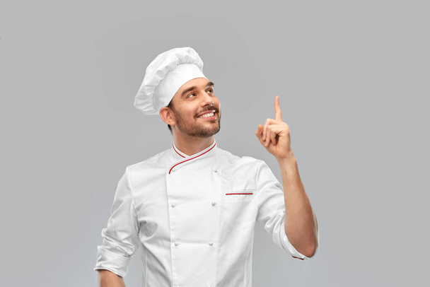 happy smiling male chef pointing finger up - Zdjęcie, obraz