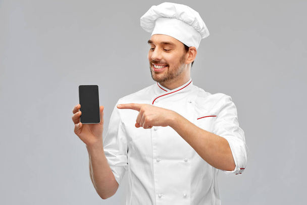 happy smiling male chef showing smartphone - Fotó, kép