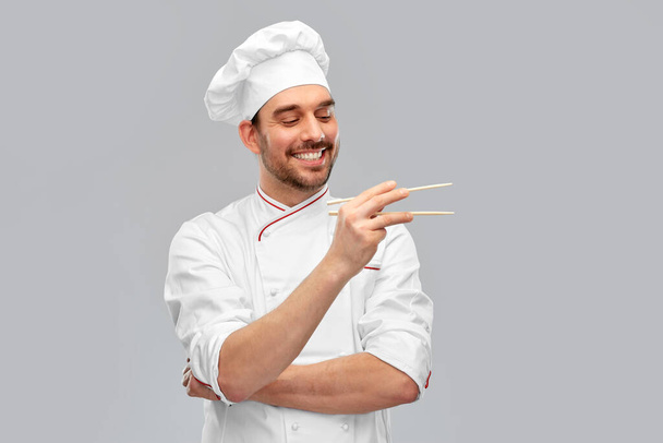 happy smiling male chef with chopsticks - Фото, изображение