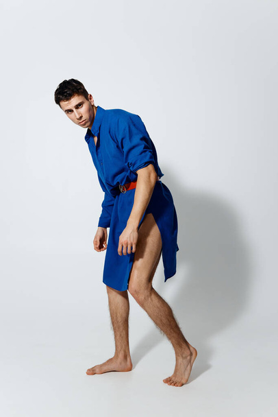 mies sinisessä mekossa kevyellä taustalla homo malli  - Valokuva, kuva