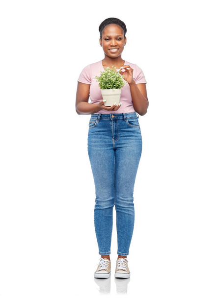 happy smiling african woman holding flower in pot - Foto, Bild