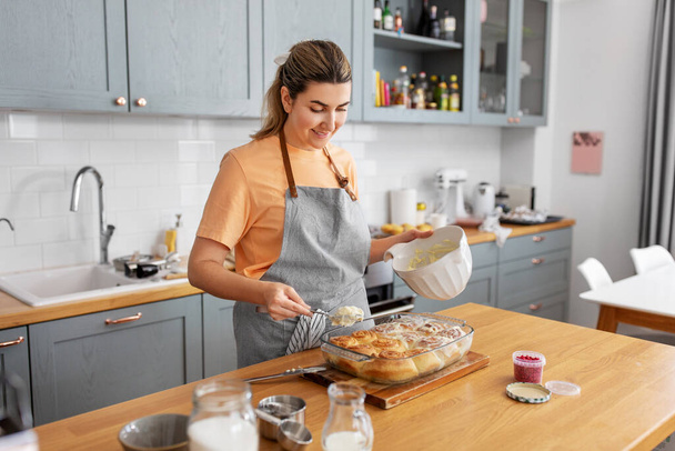 woman cooking food and baking buns at home kitchen - Fotó, kép
