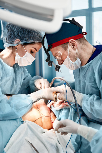 Chirurg z asystentką operuje kobiece piersi, mammoplastykę, onkologię piersi. - Zdjęcie, obraz