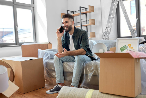 happy man calling on smartphone moving to new home - Photo, image