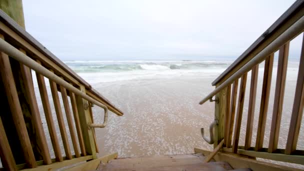 colpo statico dalla cima dei gradini della casa sulla spiaggia guardando l'acqua che si lava sulla riva - Filmati, video
