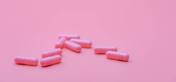 Pink capsule pills on pink background. Pharmaceutical industry. Health and medicine. Pharmacy banner. Pills of love. Treatment and care for love. Online pharmacy background. Vitamins and supplements. - Photo, image