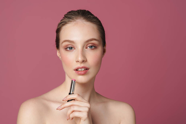 Beautiful young woman with pink lipstick standing over isolated background - Фото, зображення