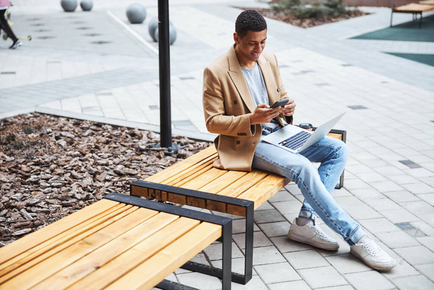 Young brunette man reading message on smartphone - Foto, Imagen