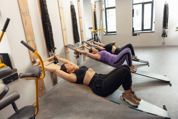 Athletic multinational people doing exercise with elastic rope in gym - Valokuva, kuva