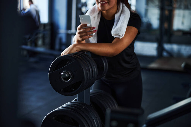 Smiling woman resting with smartphone after workout - Zdjęcie, obraz