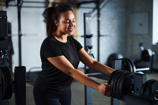 Happy woman doing workout with barbell in gym - Zdjęcie, obraz