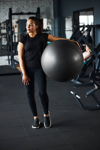 Jolly fitness trainer using fitball in gym - Zdjęcie, obraz