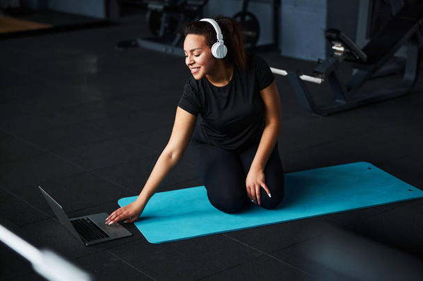 Happy woman starting training with notebook in gym - Фото, зображення