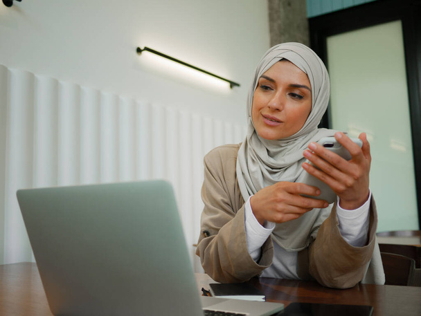 Mujer musulmana en trabajo remoto, educación en línea o conversación en video en caffe - Foto, Imagen