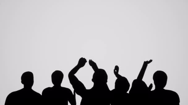 Een kleine groep van silhouetted mensen juichen - Video