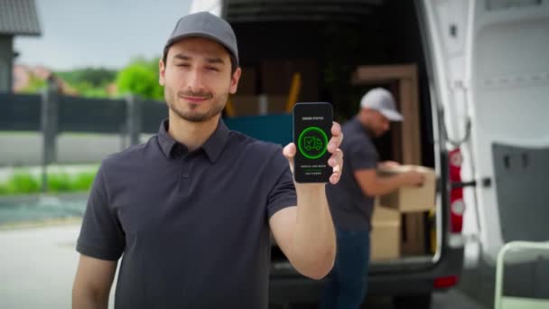 Vídeo do homem de entrega segurando móvel com aplicativo móvel. Tiro com câmera de hélio vermelho em 8K. - Filmagem, Vídeo
