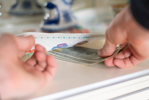 hand taking hidden stash of cash money from the wardrobe at home - Zdjęcie, obraz