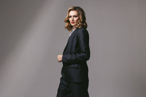 Stylish business successful confident woman in black work suit. Businesswoman in an oversized jacket looking forward. Goal setting. headway ahead . Work dress code. Men's suit. Red lipstick. feminist - Foto, immagini