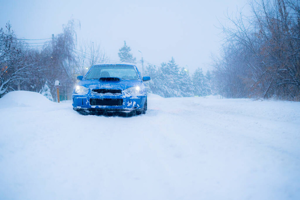 una macchina sportiva blu veloce in inverno giorno nevoso, stagione fredda, strada - Foto, immagini