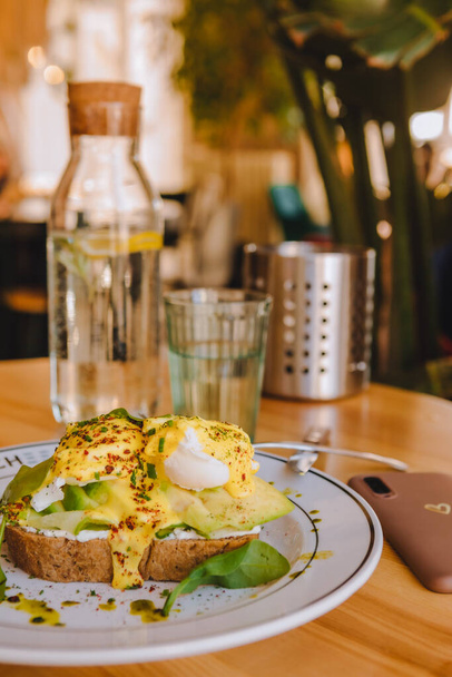 pane tostato con avocado e uova sul piatto nel ristorante colori marrone copiare spazio - Foto, immagini