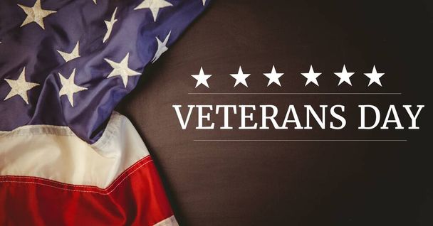Composition of text veterans day in white with stars on black with american flag. patriotism, independence and celebration concept digitally generated image. - Фото, изображение
