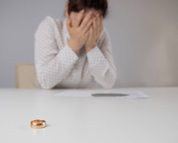 Widow mourns the death of her husband. Caucasian woman signs divorce papers and cries - 写真・画像