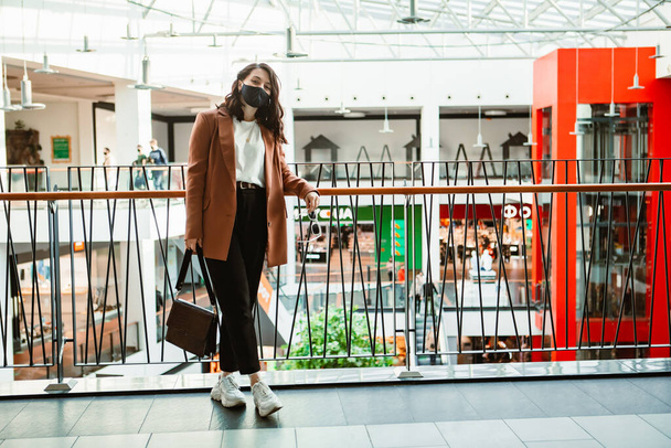woman in medical mask walking by shopping mall store consumer - Фото, зображення