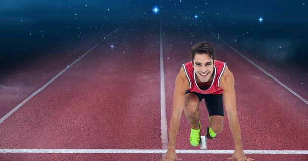 Portrait d'athlète caucasien masculin en position de départ pour courir sur un terrain de sport contre des étoiles brillantes. compétition sportive et concept de tournoi - Photo, image