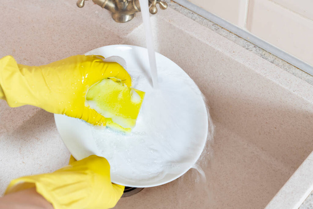 kädet pitämällä likainen astia ja pese se keittiön pesuallas kaatamalla vettä - Valokuva, kuva