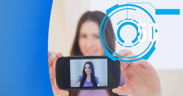 5g text and round scanner over woman taking a selfie from smartphone against technology background. global networking and technology concept - Foto, afbeelding