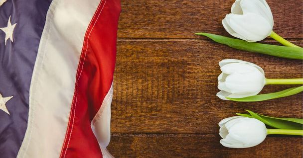 American flag and white tulip flowers on wooden background. american patriotism template background design concept - Photo, Image