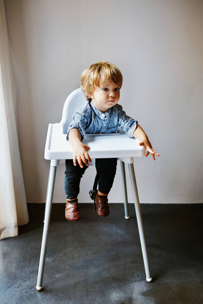 Un disparo de un adorable niño sentado en su silla alta - Foto, imagen