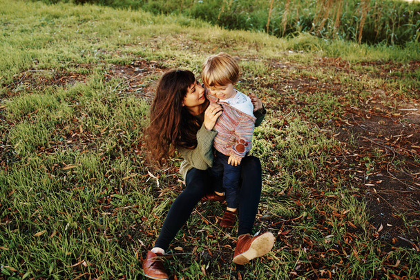 Een foto van een alleenstaande moeder die wat tijd doorbracht in het park met haar zoon. - Foto, afbeelding