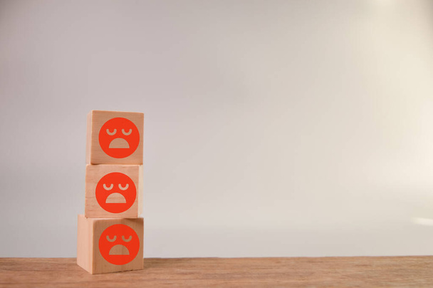 sad face wooden blocks in a row. Customer evaluation and satisfaction concept. - Photo, Image