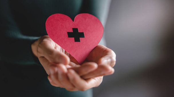 Liefde, Gezondheidszorg, Donatie en Liefdadigheid Concept. Close-up van vrijwilliger die een hart vorm papier - Foto, afbeelding