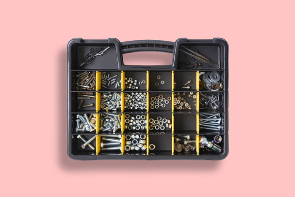 інструментальна коробка з елементами з гвинтами, якорями, цвяхами, болтами та іншими інструментами в майстерні
 - Фото, зображення