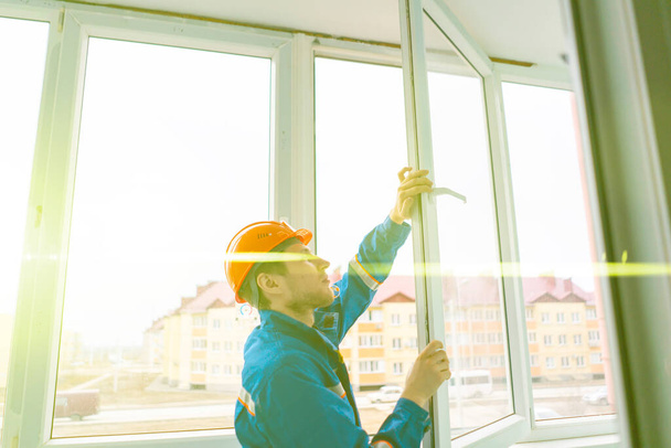 профессиональный рабочий устанавливает и настраивает окно в доме - Фото, изображение