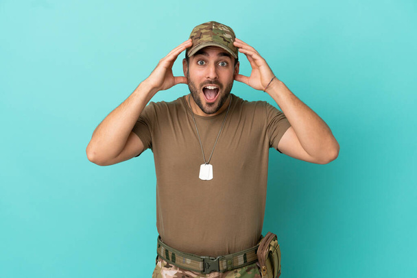 Military with dog tag over isolated on blue background with surprise expression - Photo, Image