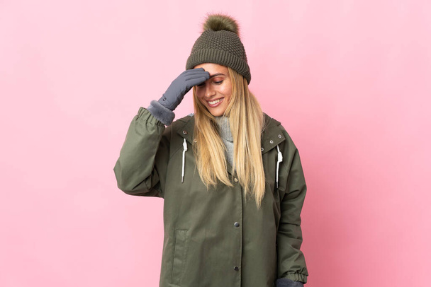 Young woman with winter hat isolated on pink background laughing - Foto, Bild