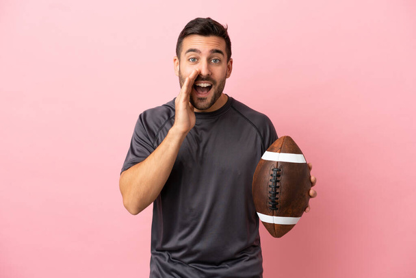 Young caucasian man playing rugby isolated on pink background shouting with mouth wide open - Photo, Image