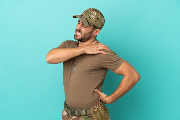 Military with dog tag over isolated on blue background suffering from pain in shoulder for having made an effort - Fotografie, Obrázek